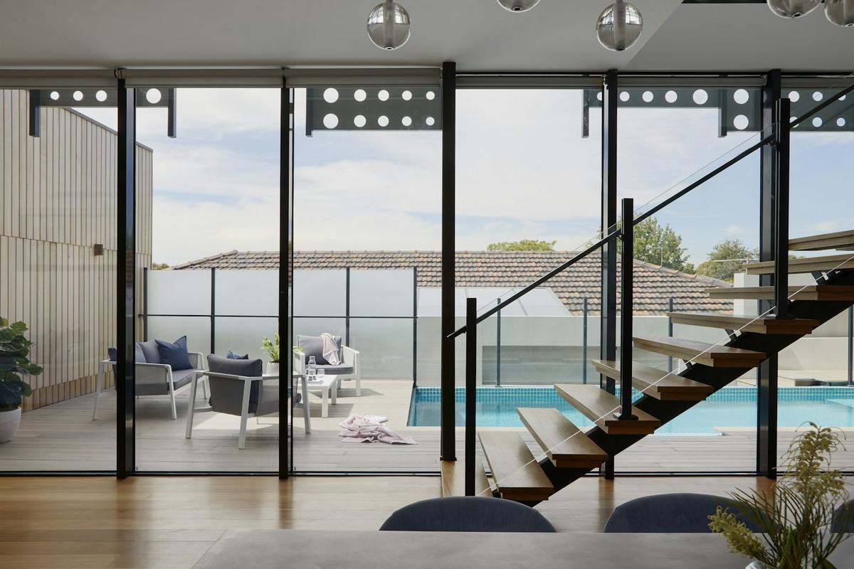 Open living space with a floating staircase and pool beyond