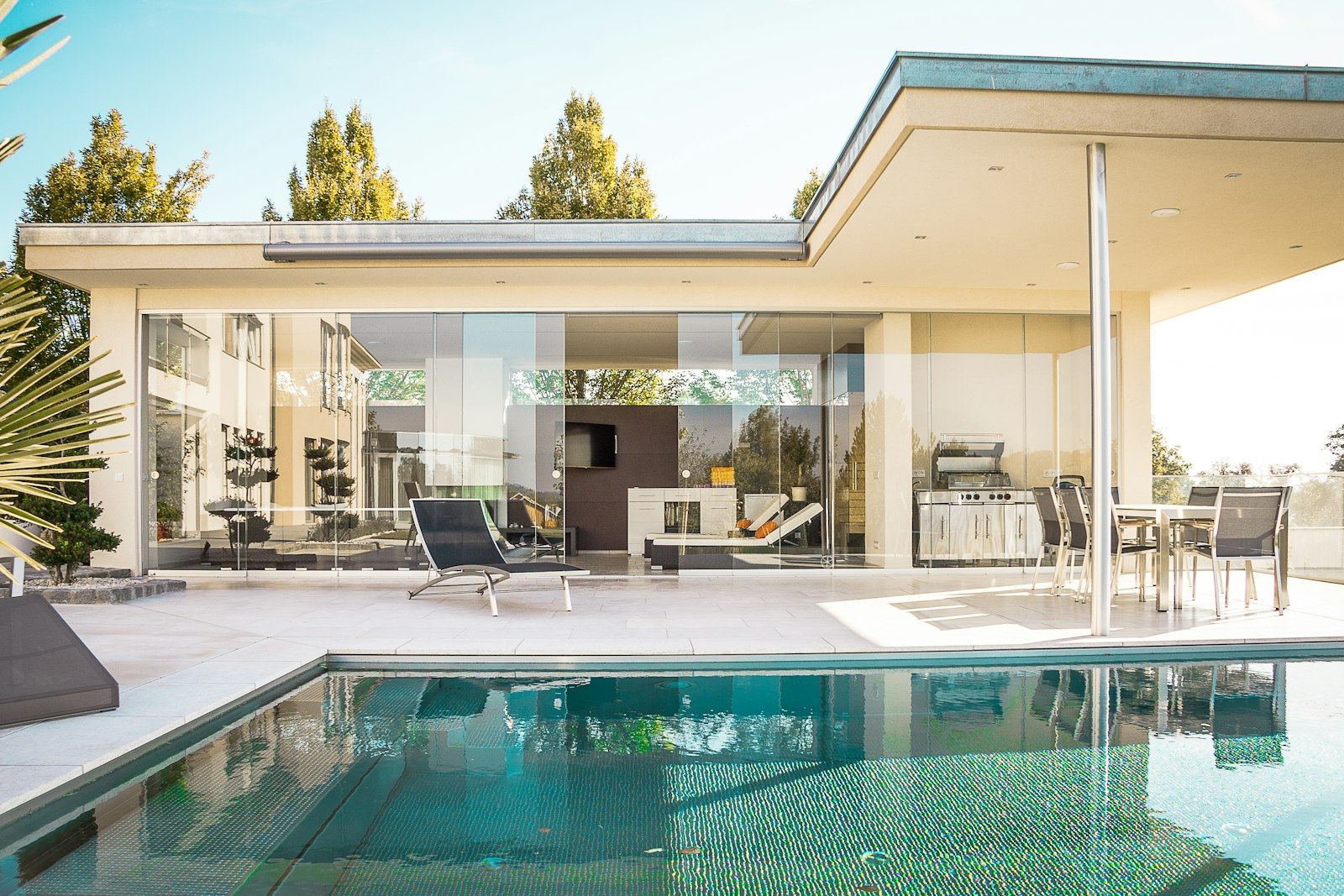 Glass pavilion house beside a reflecting pool