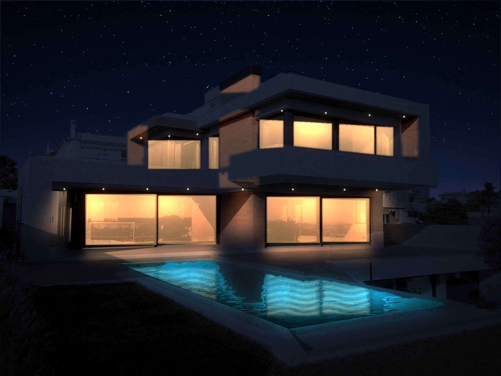The same villa at night, rooms lit and the pool glowing
